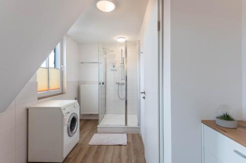 a bathroom with a washing machine and a shower at Haus Hein Mück in Norden