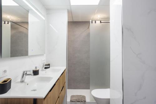 a white bathroom with a shower and a sink at Gandiazar Beach in Playa de Gandia