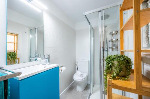 a bathroom with a toilet and a sink and a mirror at Marina 48 Seafront Apartment in Port de Soller