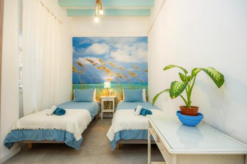 two beds in a room with a painting on the wall at Marina 48 Seafront Apartment in Port de Soller