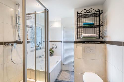 a bathroom with a shower and a toilet and a tub at Bergisch Resort Helle in Lindlar