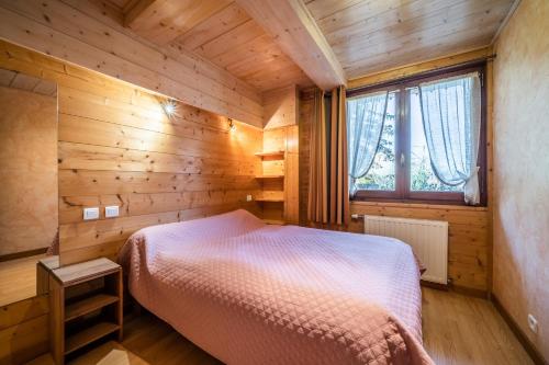a bedroom with a bed in a wooden room at Studio Chénives - Morzine in Morzine