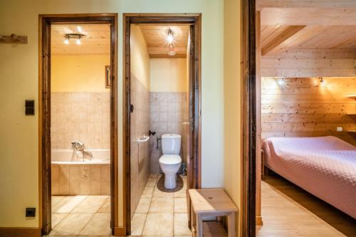 a bathroom with a toilet and a bed and a tub at Studio Chénives - Morzine in Morzine