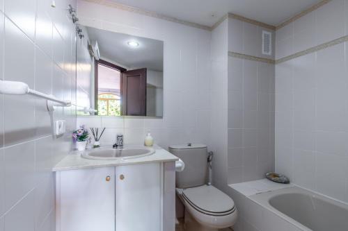 a white bathroom with a toilet and a sink at Simplicity luxury apartment in Altea
