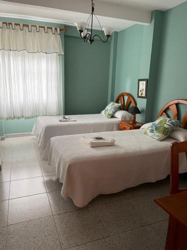 two beds in a room with blue walls at La Granja in Los Llanos de Aridane