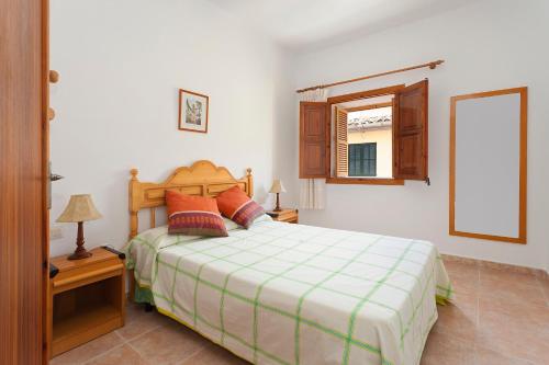 a bedroom with a bed and a window and a mirror at Sa Raval in Maria de la Salut