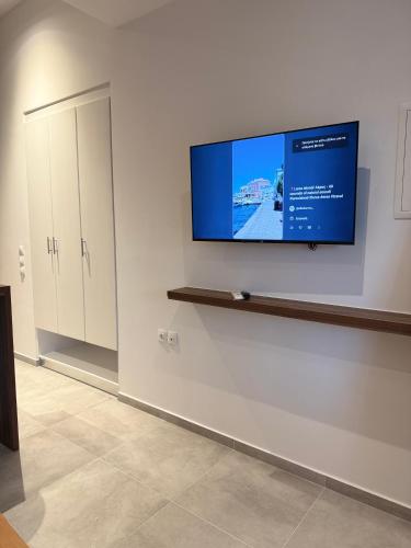 a flat screen tv on a wall in a room at Kamara Studios in Alinda