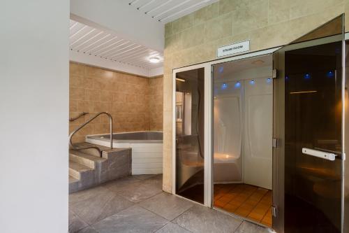 a bathroom with a bath tub and a glass door at Northfield Hotel in Minehead