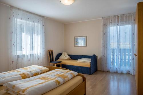 a bedroom with two beds and a couch at Valtlhof - Apt 2 in Cornaiano