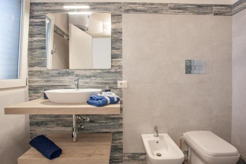 a bathroom with a sink and a toilet at Casa Bella Vista in Budoni