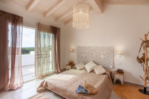 a bedroom with a bed and a large window at Casa Bella Vista in Budoni