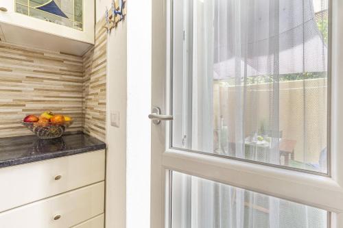 a door to a kitchen with a bowl of fruit at NURAS - Casa IAIA Alghero city center in Alghero