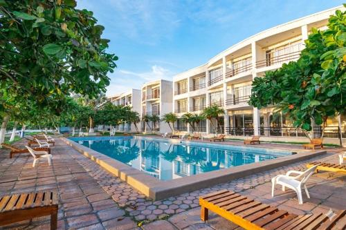 a hotel with a swimming pool in front of a building at Hotel Mediterráneo in Barra de Tuxpan
