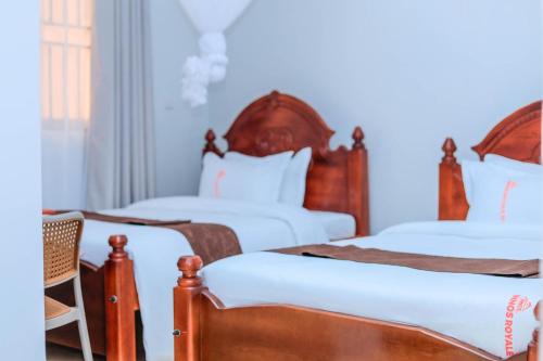 a bedroom with two beds with white sheets at Innos Royale Suites in Rukungiri