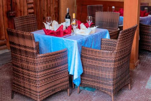 a table with a blue table cloth and wine glasses at Innos Royale Suites in Rukungiri