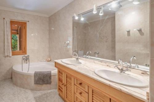 a bathroom with two sinks and a tub and a mirror at Villa Ginebro Puerto Pollença in Port de Pollensa