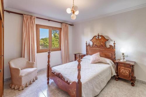 a bedroom with a bed and a chair and a window at Villa Ginebro Puerto Pollença in Port de Pollensa