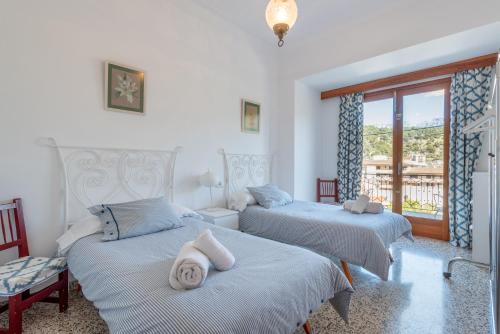 a bedroom with two beds and a window at Can Joi 12 in Sóller