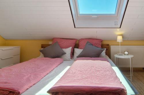 two beds in a room with a window at Joos Boardinghouse in Radolfzell am Bodensee