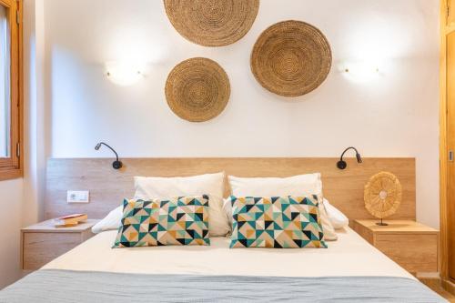 a bedroom with a bed with baskets on the wall at Holytom Puerto Pollensa in Port de Pollensa