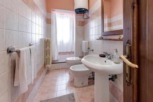 a bathroom with a white sink and a toilet at Villa L'incompiuta in Gattaia