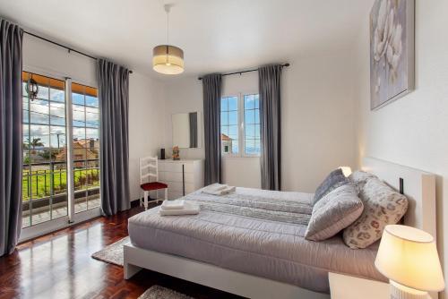 a bedroom with a large bed and a balcony at Apartamento Maria in Canhas