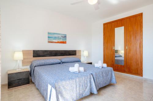 a bedroom with a bed with two candles on it at Apartamentos Karin 2ºe in Cala d´Or