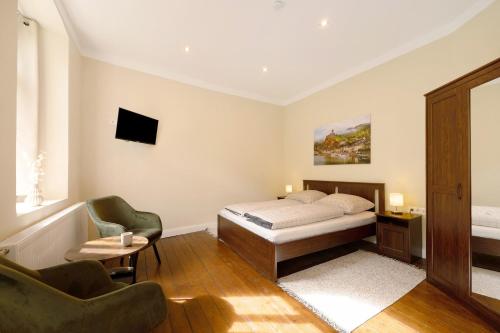 a bedroom with a bed and two chairs at Alte Stadtvilla am Weinberg 4 in Traben-Trarbach
