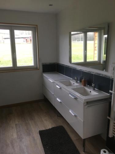 a bathroom with two sinks and two windows at Gîte Le clos du bannet in Givonne