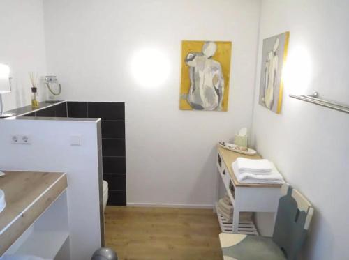 a white kitchen with a desk and a table at kleines Landhaus Bodensee in Überlingen