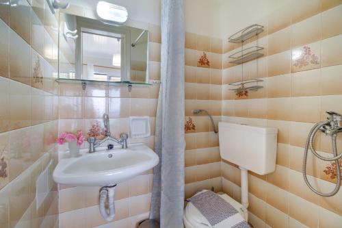 a bathroom with a sink and a toilet and a mirror at S9 room in Nikiana