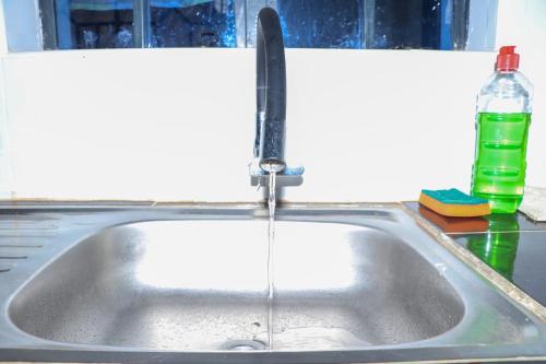 eine Küchenspüle mit Wasser aus einem Wasserhahn in der Unterkunft Els BnB in Bungoma