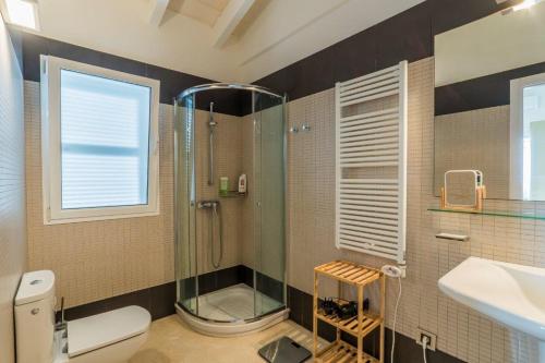 a bathroom with a shower and a toilet and a sink at Villa Mariposa in Sant Lluis