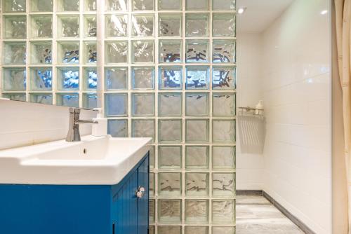a bathroom with a sink and glass block wall at Finca Las Nuevas Casa Sofia in Alora