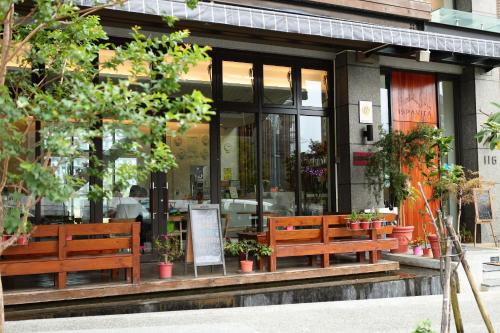 a restaurant with benches in front of a building at ISPAVITA B&B Resort in Jiaoxi