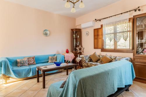 a living room with a blue couch and a table at Moraki Apartment 2 Andros in Korthi
