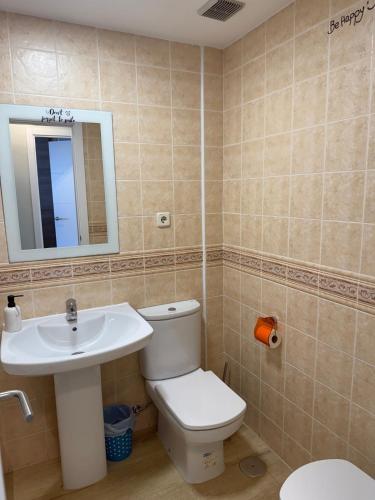 a bathroom with a toilet and a sink and a mirror at Corralejo Branded Residensed in Corralejo