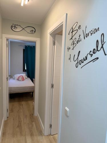 a bedroom with a door with a sign that reads be best version of yourself at Corralejo Branded Residensed in Corralejo