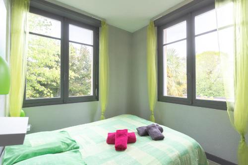 a bedroom with two presents on a bed with windows at T3 ensoleillé le Vignemale in Lourdes