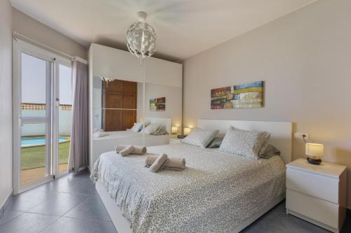 a bedroom with two beds and a large window at Casa Betta in Costa Calma