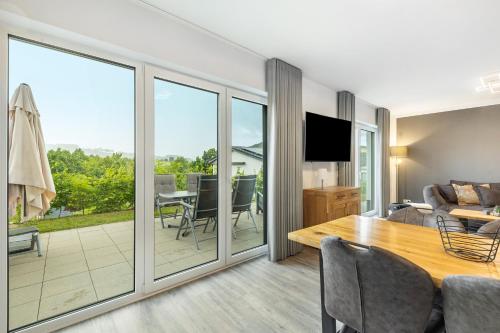 a dining room and living room with sliding glass doors at Ferienhaus Diemelblick in Heringhausen