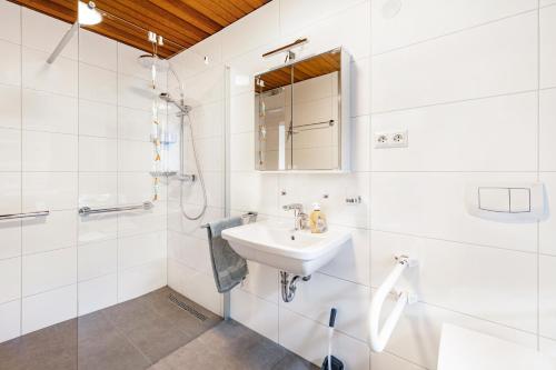 a white bathroom with a sink and a shower at Kempers Auszeit in Plettenberg
