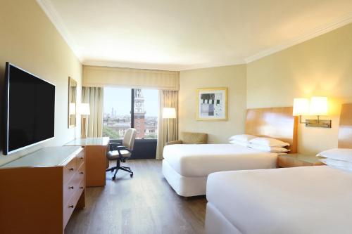 a hotel room with two beds and a flat screen tv at Sheraton Buenos Aires Hotel & Convention Center in Buenos Aires