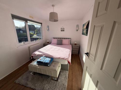 a small bedroom with a bed and a window at Edwards cabin in Caeathro