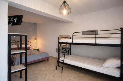 a room with three bunk beds and a lamp at Studios River - Potos Escape with Pool and Views in Potos
