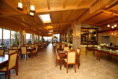 a restaurant with wooden ceilings and tables and chairs at Hotel VD Roleks in Vlorë