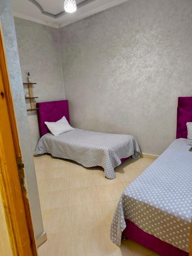 a room with two beds and a cross on the wall at Dar dyafa in Meknès