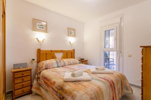 a bedroom with a bed with two towels on it at Heads 2 Holiday Homes Apartment in Villamartin