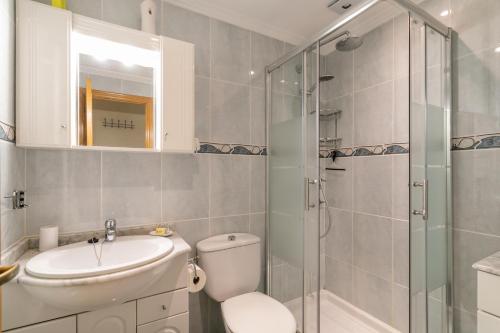 a bathroom with a toilet and a sink and a shower at Heads 2 Holiday Homes Apartment in Villamartin