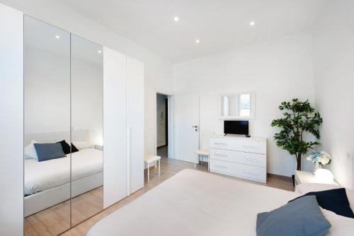 a white bedroom with a bed and a mirror at Rosa dei Venti - Centro Storico in Varazze